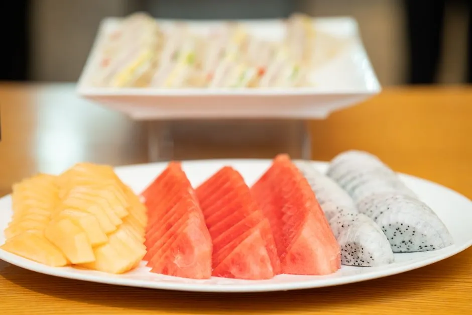 Vibrant sliced seasonal fruit including mango and watermelon on a plate