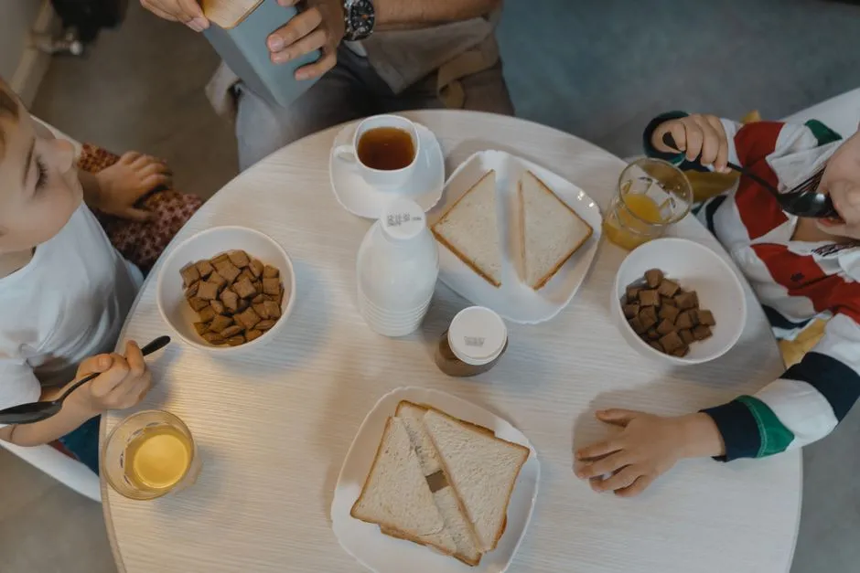 Children eating breakfast together at a round dining table